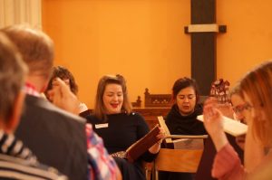 A photo of some of the alto singers mid-song as viewed from the tenor section. 